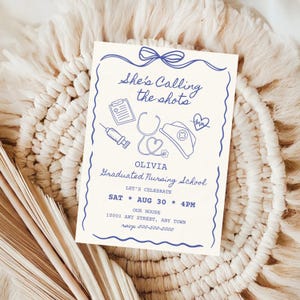 以下が含まれることがあります： クリーム色の招待状で、青色のイラストとテキストが描かれています。「She's Calling the shots」と「Graduated Nursing School」の文字。注射器、聴診器、看護師の帽子が含まれています。