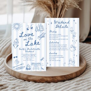 May include: Two blue and white cards with the text "Love on the Lake" and "Emily's Bachelorette Weekend". The cards feature illustrations of a bikini, sunglasses, and a dock. The second card lists weekend details.