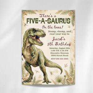 Puede incluir: Una invitación de cumpleaños con una ilustración de un Tyrannosaurus Rex verde. El texto dice "There's a FIVE-A-SAURUS On the loose!" e incluye detalles para el 5º cumpleaños de Jacob, como la fecha, la hora y el lugar.