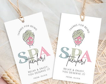 May include: Two white spa-themed gift tags with the text "THANKS FOR BEING" and "SPA-tacular!" in a stylish font. Each tag features a cartoon illustration of a person with a face mask and a towel on their head. The tags also read "RELAX & ENJOY, YOU DESERVE IT!" and "FROM: OLIVIA".
