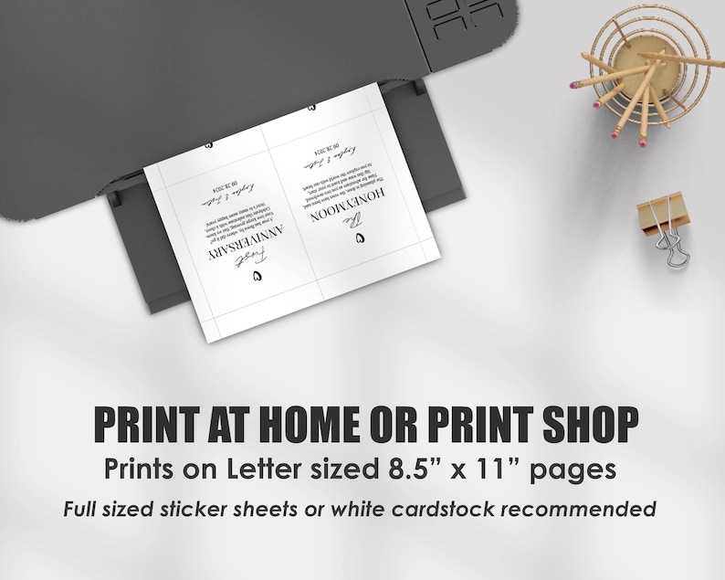 May include: A black printer outputting a white sheet of paper with two printed cards featuring black text and heart icons. The text reads First Anniversary and The Honeymoon with dates. The image includes text stating Print at home or print shop.