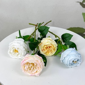 May include: Four artificial rose stems with different coloured blooms. The roses are white, light pink, yellow, and light blue.