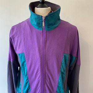 May include: A purple, teal, and gray vintage tracksuit jacket with a zipper closure and the text "Running Star" on the right side.