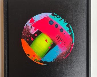 Puede incluir: Un marco cuadrado negro que contiene una pintura abstracta circular sobre un fondo negro. El diseño circular presenta trazos de pintura neón rosa, verde lima, azul brillante y naranja con salpicaduras de pintura y tres puntos circulares oscuros.