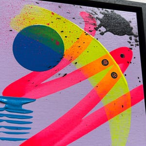 Puede incluir: Una pintura abstracta sobre lienzo en un marco negro con fondo lavanda, pinceladas en rosa y amarillo ne&oacute;n, un c&iacute;rculo azul s&oacute;lido, una forma horizontal azul texturizada y salpicaduras de pintura negra sobre la superficie.