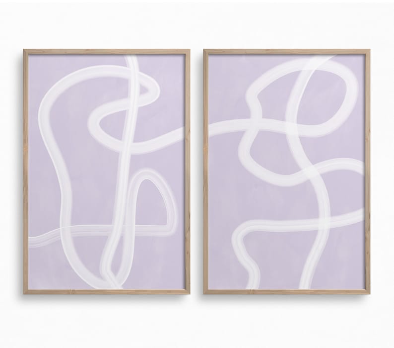 May include: Two framed abstract art prints with a light purple background and white abstract lines. The prints are in wooden frames.
