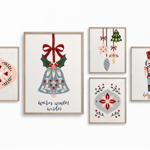 May include: Five framed Christmas art prints. Designs include a pink and red ornament, a blue bell with holly, a cluster of ornaments, a grey and red floral design, and a nutcracker with the text "holly jolly".