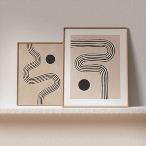 Puede incluir: Dos impresiones de arte abstracto enmarcadas con l&iacute;neas negras y c&iacute;rculos sobre un fondo beige. Las impresiones est&aacute;n en marcos de madera y est&aacute;n colgadas en una pared blanca.