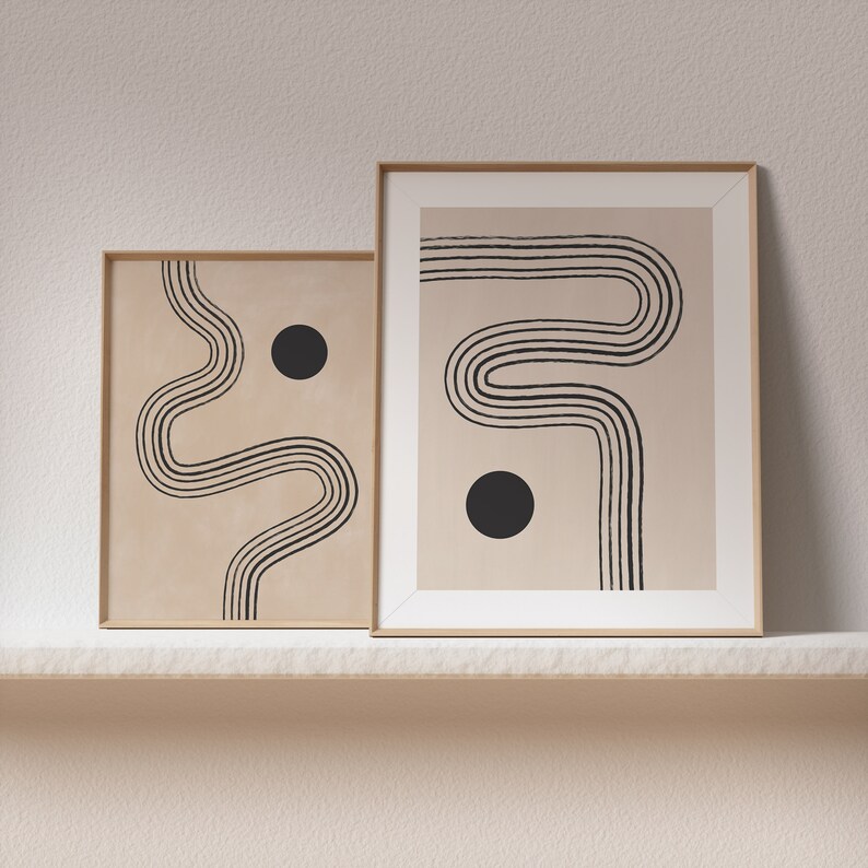 Puede incluir: Dos impresiones de arte abstracto enmarcadas con l&iacute;neas negras y c&iacute;rculos sobre un fondo beige. Las impresiones est&aacute;n en marcos de madera y est&aacute;n colgadas en una pared blanca.