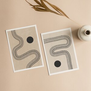 Puede incluir: Dos impresiones de arte minimalistas con l&iacute;neas negras y c&iacute;rculos sobre un fondo beige. Las impresiones est&aacute;n enmarcadas y tienen un borde blanco.