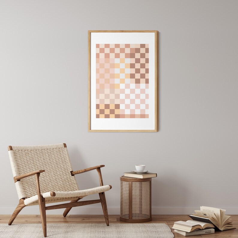 May include: A wooden chair with a woven seat and back, a small round side table with a woven top, and a framed print of a geometric pattern in shades of pink, orange, and brown. The print is hanging on a light gray wall.