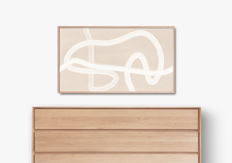 Puede incluir: Una impresi&oacute;n de arte abstracto enmarcada con l&iacute;neas blancas sobre un fondo beige. La impresi&oacute;n est&aacute; colgada sobre una c&oacute;moda de madera con cuatro cajones.
