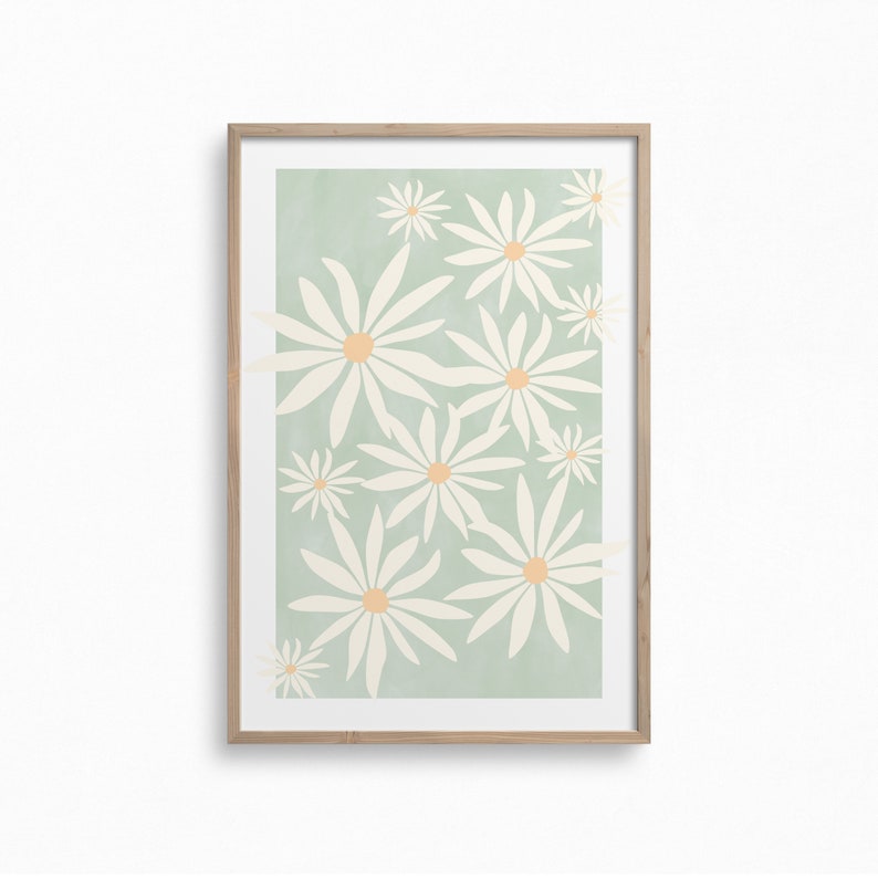 May include: A framed print with a light green background and a pattern of white daisies with orange centers.