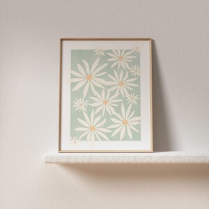 May include: A framed print with a minimalist design featuring white daisies on a light green background.