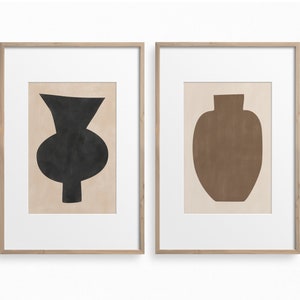 May include: Two framed prints of abstract vase silhouettes. The left print features a black vase with a rounded base and a narrow neck. The right print features a brown vase with a rounded base and a wide neck.