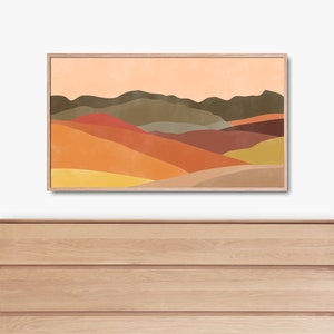 May include: Abstract landscape art print with a colorful mountain range in shades of orange, yellow, brown, and green. The print is framed in a light wood frame.