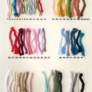 May include: A collection of 62 bundles of colorful embroidery floss, arranged in rows. The floss colors range from white to black, with various shades of pink, red, orange, yellow, green, blue, and purple. Each bundle is labeled with a number.