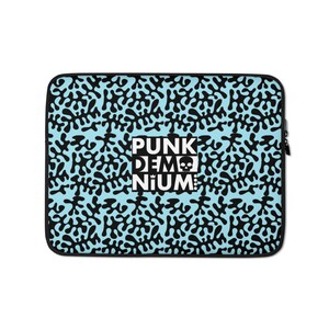 May include: A blue laptop sleeve with a black and white pattern of abstract shapes. The text "PUNK DEM NIUM" is printed in white on a black rectangle in the center of the sleeve.