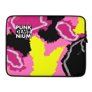 May include: A laptop sleeve with a pink, yellow, and black abstract design. The text "PUNK DEM NIUM" is printed in white on a black rectangle in the upper left corner.