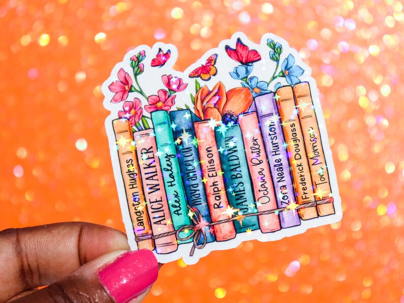 May include: A sticker featuring a stack of books with the names of authors printed on the spines. The books are surrounded by colorful flowers and butterflies. The authors include Langston Hughes, Alice Walker, Alex Haley, Maya Angelou, Ralph Ellison, James Baldwin, Octavia Butler, Zora Neale Hurston, Frederick Douglass, and Toni Morrison.