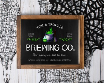 May include: A black chalkboard sign with a wooden frame, advertising a "Toil & Trouble Brewing Co." with a cauldron and a bottle of potion. The sign reads "Open daily from dusk til dawn" and lists "Witches Brew, Orge Ale, & Black Magic Margaritas".