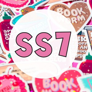 May include: A close-up of a variety of colorful stickers with different designs and text. The stickers are arranged in a random pattern and include designs such as a heart, a book, a coffee cup, and a bottle of hot sauce. The text on the stickers includes "Bookworm", "Spicy Book Club", "I Like My Coffee Icy", and "SS7".