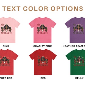 May include: A graphic design showing ten different t-shirt color options for a "The Nutcracker" design. The design features a group of three Black children dressed as nutcrackers. The text color options are: Pink, Charity Pink, Heather Team Purple, Heather Red, Red, and Kelly.