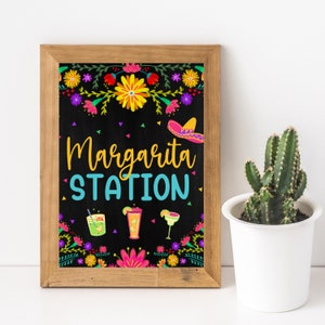 May include: A black chalkboard sign with a wooden frame, decorated with colorful flowers and a sombrero. The sign reads "Margarita Station" and features three illustrations of margarita glasses.