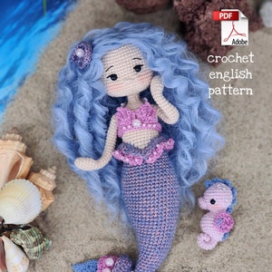 May include: Crochet pattern for a mermaid doll with blue hair, pink and purple tail, and a small seahorse. The pattern is available in English and is a PDF download.