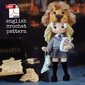 Könnte beinhalten: Häkelmuster für eine Gryffindor-Schülerpuppe mit einem Löwenkopf-Hut, die ein Buch mit dem Titel "The Quibbler" hält.