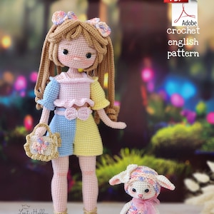 Puede incluir: Una muñeca de crochet con cabello castaño, un vestido rosa y azul y una bolsa a juego. La muñeca sostiene un pequeño cordero de crochet con una cinta rosa.