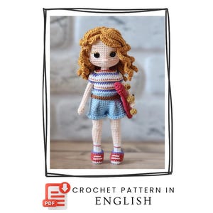 May include: A crocheted doll with orange curly hair, wearing a striped top, blue shorts, and red-striped shoes. The doll holds a red and yellow accessory. The image includes the text "CROCHET PATTERN IN ENGLISH".