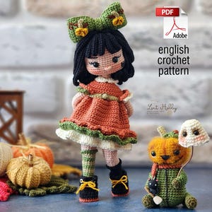Op de afbeelding: Haakpatroon voor een pompoen-pop en een spook dat een pompoen vasthoudt. De pop draagt een oranje jurk met groene en witte versiering, zwarte schoenen en een groen-wit gestreept hoofdband. Het spook draagt een witte hoed met een roze gezicht. Het patroon is beschikbaar in het Engels.