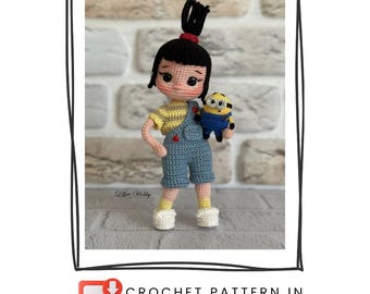 May include: A handmade crochet doll of a girl with black hair in a bun, wearing a yellow shirt and blue overalls. She holds a small Minion doll. The doll is standing on a gray surface. The image includes the text "CROCHET PATTERN IN ENGLISH".