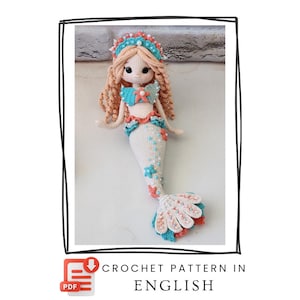 May include: A crocheted mermaid doll with light peach yarn hair, a cream-colored body, and a tail decorated with teal and coral starfish accents and white beads. The doll wears a matching teal and coral crown and top. Text reads: PDF CROCHET PATTERN IN ENGLISH.