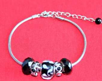 Bracelet serpentine pour dames aux accents de perles de verre et de métal.  Boucles d’oreilles assorties disponibles.