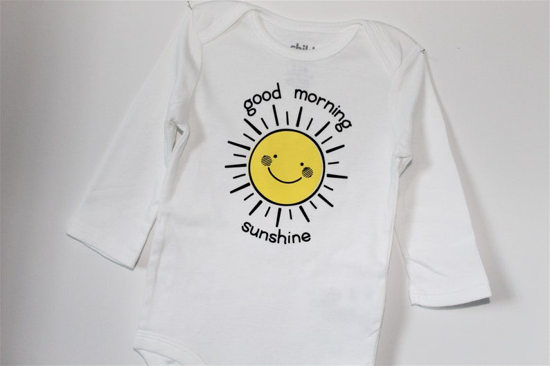 Infant boy/'sgirls/' long sleeved bodysuit with good morning sunshine lettering and yellow sun smiley face.