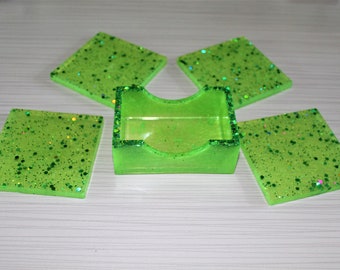 Four piece square-shaped resin beverage coaster set with matching storage case,