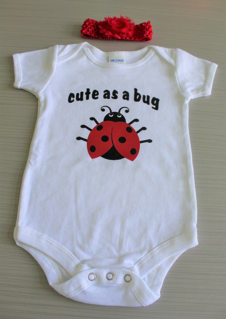 Baby girls/' white short sleeved Cute as a Bug bodysuit with a cute red and black ladybug.