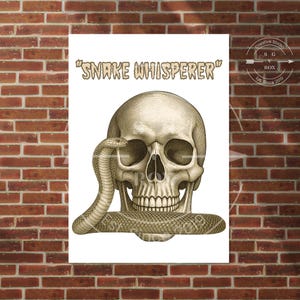 Op de afbeelding: Een witte print met een gedetailleerde, in etsstijl uitgevoerde menselijke schedel met een slang die om de basis en kaak is gewikkeld. De tekst "SNAKE WHISPERER" is in een gestileerd, verweerd lettertype boven de schedel gedrukt.