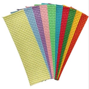 May include: A fan-shaped arrangement of ten rectangular fabric strips featuring a woven grid texture. The colors include light yellow, blue, purple, pink, light green, teal, red, dark green, yellow, and orange, all displayed in a vibrant spectrum.
