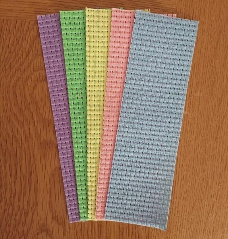 May include: Five rectangular strips of stiffened fabric arranged in a fan shape. The strips feature a distinct grid-like woven texture and come in a variety of pastel colors including purple, light green, yellow, soft pink, and light blue.