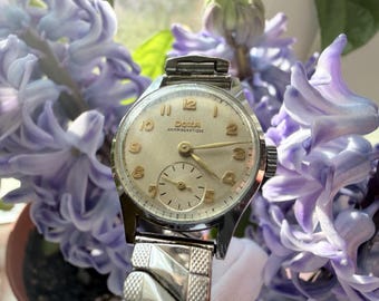 Montre femme vintage Doxa, fabrication suisse, remontage manuel, années 1960, petit cadran argenté, petite seconde, style rétro classique, pièce de collection rare.