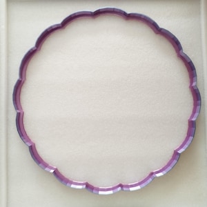 Könnte beinhalten: Ein violettes Serviertablett aus Glas mit einem gewellten Rand.