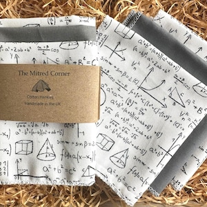 May include: A set of white cotton hankies featuring a gray border and printed with mathematical equations and diagrams. The hankies are packaged with a brown label that reads "The Mitred Corner, Cotton Hankies, Handmade in the UK."
