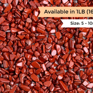 Pode incluir: Uma imagem de close-up de uma grande quantidade de pedras de jaspe vermelho polidas. As pedras são de vários tamanhos e formas, que variam de 5 a 10 milímetros. O texto "Available in 1 LB (16oz) Size: 5 - 10mm" é visível na imagem.