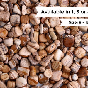 May include: A close-up image of a variety of brown and white tumbled stones. The stones are smooth and have a natural, organic look. The text "Available in 1, 3 or 8oz" and "Size: 8 - 15mm" is visible in the image.