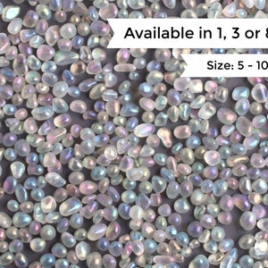 Könnte beinhalten: Nahaufnahme von irisierenden weißen Glaskieselsteinen. Die Kieselsteine haben verschiedene Formen und Größen und reichen von 5 bis 10 Millimetern. Erhältlich in 1, 3 oder 8 Unzen.