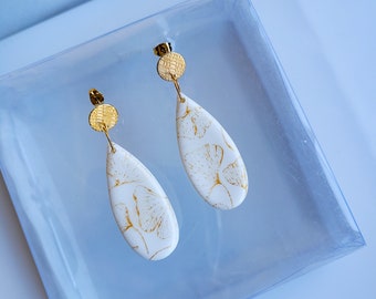 Boucles d'oreilles blanches et motifs feuilles de Gingko dorés, faits main en France en argile polymère. Création artisanale unique