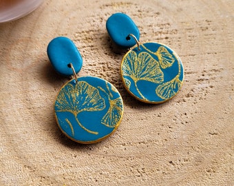 Boucles d'oreilles rondes bleu turquoise foncé, et motifs feuilles de Gingko, faits main en France, en argile polymère. Création unique